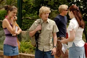 Durch Cleos (Phoebe Tonkin, li.) Schuld ist Charlotte (Brittany Birnes, re.) nass geworden. Lewis (Angus McLaren, Mitte) versucht die Situation zu retten.