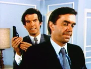 Remington Steele (Pierce Brosnan, l.) kommt dem Ganoven Raymond Merleau (James Laurenson) auf die Schliche.