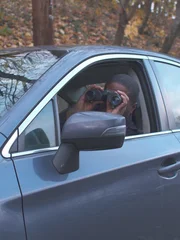 A detective spies on his suspect A detective spies on his suspect