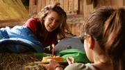 Sara (r. Lucia Luna) &uuml;berrascht Mia (l. Margot Nuccetelli) zu ihrem Geburtstag mit einer kleinen Torte.