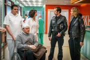 Jasmin (Gerit Kling, m.) kl&auml;rt Mattes (Matthias Schloo, 2.v.r.) und Melanie (Sanna Englund, r.) bez&uuml;glich der Verletzungen ihres Patienten, Nils Steinbach (Mirco Reseg, 2.v.l.), auf.
