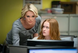Megyn Kelly (Charlize Theron, l.) und ihre Assistentin Lily (Liv Hewson, r.) sind erstaunt, als sie von der Klage gegen ihren Chef Roger Ailes und die Reaktionen darauf erfahren.