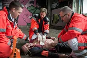 Dr. Haase (Fabian Harloff, M.) versorgt die Schusswunde eines Unbekannten, der so schnell wie m&ouml;glich ins EKH muss, da es wahrscheinlich ist, dass er innere Blutungen hat.