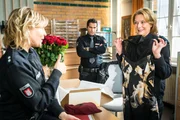 Claudia (Janette Rauch, r.) zeigt Melanie (Sanna Englund, l.) das Abendkleid, das ihr als Geschenk ins Revier geschickt wurde. Tarik (Serhat Cokgezen, M.) findet das gar nicht lustig, vermutet er doch, dass Claudia eine Aff&auml;re hat.