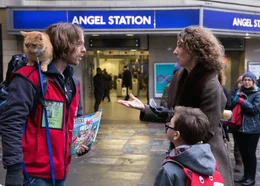 James (Luke Treadaway) im Gespräch mit einer Käuferin der Obdachlosenzeitung "The Big Issue".