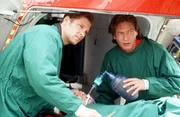 "Medicopter 117 - Jedes Leben z&auml;hlt", "Bankraub." Bank&uuml;berfall - sowohl ein R&auml;uber als auch ein Geldbote werden schwer verletzt ins Krankenhaus gebracht. W&auml;hrenddessen &uuml;berfallen die restlichen fl&uuml;chtigen Bankr&auml;uber die Helikopterbasis. Die Crew wird von den Verbrechern gezwungen, ins Krankenhaus zu fliegen, um den verletzten Bankr&auml;uber von dort zu entf&uuml;hren. Im Bild (v.li.): Manfred St&uuml;cklschwaiger (Thomas W&auml;chter), Rainer Grenkowitz (Dr. Michael L&uuml;dwitz).