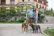 Antje (41) und Sebastian (45) mit ihren Hunden Lotti und Axel vor dem Schweriner Schloss, welches durch Gro&szlig;herzog Friedrich Franz II. von Georg Adolph Demmler und Friedrich August St&uuml;ler im Neurenaissancestil vollendet wurde.