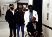 Mark (Victor French, l.), Jonathan (Michael Landon, 2.v.l.) und Dr. Sims (James Reynolds, 2.v.r.) k&uuml;mmern sich um den herzkranken Dr. Hudsbeth (Roscoe Lee Browne, r.).