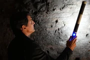 Der Archäologe Darius Arya beleuchtet die unterirdischen Überreste eines Freskos in der Domus Aurea von Kaiser Nero in Rom. Der Archäologe Darius Arya beleuchtet die unterirdischen Überreste eines Freskos in der Domus Aurea von Kaiser Nero in Rom.
