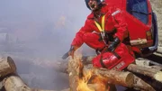 Die Bergung der verletzten Frau aus der Grube gestaltet sich durch die verkeilten Holzst&auml;mme und das Feuer &auml;u&szlig;erst kompliziert. Dr. Harland will jedoch zu ihr in die Grube hinunterklettern...
