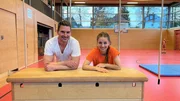 Marina und Physiotherapeut Sandro stehen hinter einem Sprungkasten. Marina und Physiotherapeut Sandro stehen hinter einem Sprungkasten.
