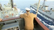 Der Kapitän des Schiffes lehnt an der Reling und beobachtet das Schiff. Der Kapitän des Schiffes lehnt an der Reling und beobachtet das Schiff.