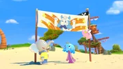 Mamfie, Takolo und Pinkie haben ein Transparent für Käpt'n Kronk am Strand aufgestellt. Mamfie, Takolo und Pinkie haben ein Transparent für Käpt'n Kronk am Strand aufgestellt.