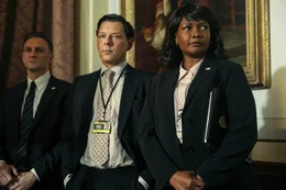 Quincy Harrington (Richard Coyle, M.) und Simone Bradshaw (Sarah Niles, r.) beobachten interessiert den Auftritt ihrer Chefs.