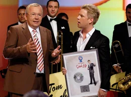 Am 7. Juli j&auml;hrt sich zum ersten Mal der Todestag von Rudi Carrell, dem unumstrittenen Meister der deutschen Fernsehunterhaltung. Moderator Bernd Stelter hat sich aus diesem Anlass prominente Freunde, Wegbegleiter, Bewunderer und Fans von Rudi eingeladen, um mit ihnen noch einmal an den Menschen, den Entertainer, den Musiker und genialen Unterhalter Rudi Carrell zu erinnern. - Gastgeber und Moderator Bernd Stelter &uuml;berreicht einen Jazz-Preis an Bandleader Tom G&auml;bel.