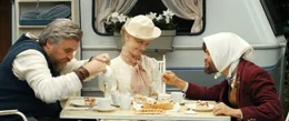 Eine Eintagsfliege hat nur einmal Geburtstag. Wildschwein (Aljoscha Stadelmann), die fr&ouml;hliche Eintagsfliege (Karoline Schuch) und Fuchs (Lars Rudolph) essen an einem Campingtisch.