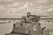 Ein Soldat in einem M5 Stuart-Panzer aus dem Zweiten Weltkrieg, der mit einem Maschinengewehr vom Kaliber 50 ausgestattet ist. Ein Soldat in einem M5 Stuart-Panzer aus dem Zweiten Weltkrieg, der mit einem Maschinengewehr vom Kaliber 50 ausgestattet ist.