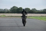 Dunsfold, Guildford, UK: A motorbiker pulling a wheelie. Dunsfold, Guildford, UK: A motorbiker pulling a wheelie.