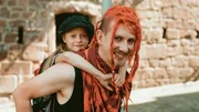 Ein Punk trägt Isabel Huckepack. Ein Punk trägt Isabel Huckepack.