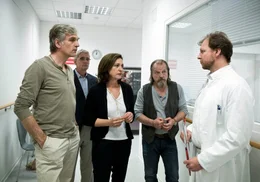 Eckart (Hans-Uwe Bauer, 2. v. li.), Philip (Walter Sittler, li.), Harry (Paul Fassnacht) und Ricarda (Charlotte Schwab) erfahren vom Stationsarzt (Guido Renner) die bittere Diagnose ihrer Mitbewohnerin Uschi.