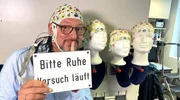 Eckart von Hirschhausen (Mitte) bereitet sich mit einer EEG-Haube auf ein Gedanken-Experiment im Leibniz-Institut f&uuml;r Neurobiologie Magdeburg vor.