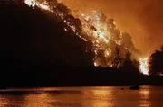 Ein Feuer w&uuml;tet in den W&auml;ldern der griechischen Insel Eub&ouml;a und f&auml;rbt den Nachthimmel im Jahr 2021 orange &ndash; es sollte sich um den bis dahin gr&ouml;&szlig;ten Waldbrand in der j&uuml;ngeren griechischen Geschichte handeln.