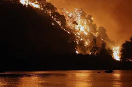 Ein Feuer w&uuml;tet in den W&auml;ldern der griechischen Insel Eub&ouml;a und f&auml;rbt den Nachthimmel im Jahr 2021 orange &ndash; es sollte sich um den bis dahin gr&ouml;&szlig;ten Waldbrand in der j&uuml;ngeren griechischen Geschichte handeln.