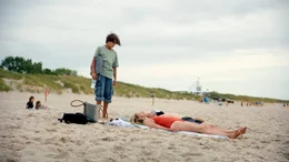 Linus (Linus Kranich) f&uuml;hlt sich von seinen Eltern (Gabija Jaraminait&eacute;, Mathis Reninhardt) nicht beachtet. Er schnappt sich seine Sachen und verl&auml;sst den Strand.