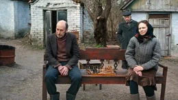 Anatoliy (Oleksandr Maksiakov) und Anna (Radmila Shchogolieva) sitzen auf einer Bank.