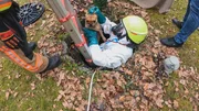 Team bei der Rettung einer kleinen französischen Bulldogge, die in eine Klärgrube gefallen ist. Team bei der Rettung einer kleinen französischen Bulldogge, die in eine Klärgrube gefallen ist.