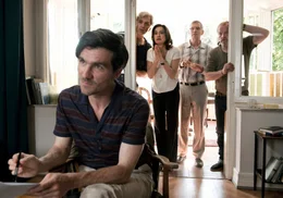 Der Gutachter Fabian (S&eacute;an McDonagh) versucht herauszufinden, welcher Pflegestufe Uschis Behinderung entspricht. Eckart (Hans-Uwe Bauer, 2. v. re.), Philip (Walter Sittler, li.), Harry (Paul Fassnacht) und Ricarda (Charlotte Schwab) versuchten Uschi pantomimisch zu signalisieren, dass sie die Sache ruhig ein wenig dramatischer darstellen kann.