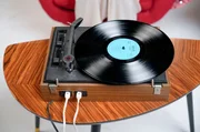 Ein Plattenspieler als Symbol für kulturelle Lenkung: Als der Rock 'n' Roll aus dem Westen Ostdeutschland erreichte, versuchte der Staat mit dem eigens entwickelten Tanz "Lipsi" gegenzusteuern. Hintergrund war die Sorge der DDR-Führung, dass die aus dem Westen kommende Musik des Rock 'n' Roll und andere amerikanische Tanzstile, wie Twist und Boogie-Woogie, auf die Jugend Ostdeutschlands "dekadent" wirken und somit unerwünschte westliche Einflüsse fördern könnten. Der neue, staatlich verordnete Tanzstil sollte den jugendlichen Zeitgeist einfangen – blieb jedoch ein Flop, während westliche Musik weiterhin heimlich auf den Plattentellern drehte. Ein Plattenspieler als Symbol für kulturelle Lenkung: Als der Rock 'n' Roll aus dem Westen Ostdeutschland erreichte, versuchte der Staat mit dem eigens entwickelten Tanz "Lipsi" gegenzusteuern. Hintergrund war die Sorge der DDR-Führung, dass die aus dem Westen kommende Musik des Rock 'n' Roll und andere amerikanische Tanzstile, wie Twist und Boogie-Woogie, auf die Jugend Ostdeutschlands "dekadent" wirken und somit unerwünschte westliche Einflüsse fördern könnten. Der neue, staatlich verordnete Tanzstil sollte den jugendlichen Zeitgeist einfangen – blieb jedoch ein Flop, während westliche Musik weiterhin heimlich auf den Plattentellern drehte.