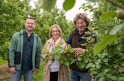 Christoph Abel (r) f&uuml;hrt Yvonne Willicks (Mitte) und Florian Milke (l) &uuml;ber seine Apfelplantage.