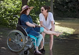 Ricarda (Charlotte Schwab, rechts) k&uuml;mmert sich liebevoll um ihre Mitbewohnerin und Freundin Uschi (Marie Gruber), die nach einem Schlaganfall im Rollstuhl sitzt.