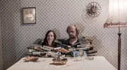 Mutter (Beate D&uuml;ber) und Vater (Matthias Zwarg ) sitzen vor einem Berg B&uuml;cher.