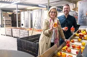 Yvonne Willicks (l) darf heute ordentlich mit anpacken. Am Sortierband von Fruchtsaftproduzent Florian Milke (r) darf Deutschlands bekannteste Hauswirtschaftsmeisterin mitsortieren. Nur die sch&ouml;nsten landen sp&auml;ter im Apfelsaft.