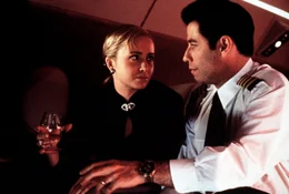 Die attraktive Samantha (Lysette Anthony, l.) schmei&szlig;t sich an ihren neuen Angestellten James (John Travolta, r.) ran. Und als braver Angestellter ist James nat&uuml;rlich gezwungen, Gewehr bei Fu&szlig; zu stehen, ob er will oder nicht.
