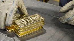 M&auml;nnerh&auml;nde mit Arbeitshandschuhen sortieren Goldbarren in der Raffinerie Valcambi in der Schweiz.