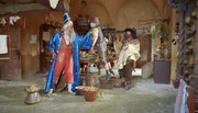 Zauberer Zwackelmann (Rufus Beck, li.) hat Seppel  (Manuel Steitz) am Schlafittchen. Der R&auml;uber Hotzenplotz (Armin Rohde, re.) schaut zu.