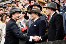 Auf der Trib&uuml;źne des Reichsparteitag in Nź&uuml;rnberg, inmitten von NSDAP-Politikern, Wehrmachtssoldaten und Gesch&auml;&Scaron;ftsm&auml;&Scaron;nnern (Komparsen), stellt Rudi Dassler (Torben Liebrecht, M.) seinem Bruder Adi Dassler (Ken Duken, r.) Josef Waitzer (David C. Bunners, l.) vor.