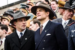 Adi (Ken Duken, l.) und Rudi Dassler (Torben Liebrecht) auf der Trib&uuml;ne des Reichsparteitag in N&uuml;rnberg bei der Sport-Gleichschaltung inmitten von NSDAP-Politikern, Wehrmachtssoldaten und Gesch&auml;ftsm&auml;nnern (Komparsen).
