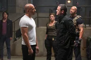 Dom (Vin Diesel, 2.v.l.), Hobbs (Dwayne "The Rock" Johnson, r.), Riley (Gina Carano, 3.v.r.) und Doms Crew (l. Sung Kang als Han) konnten Shaw (Luke Evans) zwar endlich festnehmen, doch der hat noch ein Ass im &Auml;rmel und versucht Dom zu erpressen...