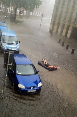 Schon nach der ersten Welle, waren die Stra&szlig;en der Stadt M&uuml;nster &uuml;berflutet. Ein Student durchquert die Altstadt auf der Luftmatratze.