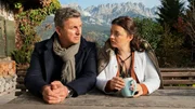 Der Bergdoktor Staffel 15 Was bleibt – Teil 1 Mann und junge Frau sitzen an Holztisch im Freien: Hans Sigl als Bergdoktor Dr. Martin Gruber, Ronja Forcher als Lilli Gruber Der Bergdoktor Staffel 15 Was bleibt – Teil 1 Mann und junge Frau sitzen an Holztisch im Freien: Hans Sigl als Bergdoktor Dr. Martin Gruber, Ronja Forcher als Lilli Gruber