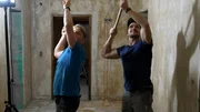 Thomas Wittenberg und Mike Schopp rei&szlig;en die alte Tapete von der Decke ab