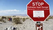 Weltweit werden neue Hitzerekorde aufgestellt. Woher r&uuml;hren immer extremere Hitzeperioden? Im Death Valley National Park wurde am 16. August 2020 die h&ouml;chste jemals gemessene Temperatur von 54,4&deg; C oder 130&deg; Fahrenheit gemessen. Das Foto zeigt Besucher nahe eines Warnschildes, welches auf die die extremen Temperaturen aufmerksam macht.