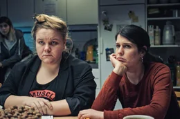 Bea (Giorgina H&auml;mmerli, re.) und Martina (Julia Gr&auml;fner, li.) sitzen am K&uuml;chentisch und diskutieren &uuml;ber den Kauf eines neuen Staubsaugers.