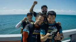 Michael (Mark Wahlberg, 2.v.l.) und sein Racing-Team: Olivia (Nathalie Emmanuel, l.), Chik (Ali Suliman, 2.v.r.) und Leo (Simu Liu, r.), der immer was zu posten hat.