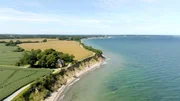 Das Brodtener Steilufer zwischen Travemünde und Lübeck ist ein „aktives Kliff“ – jedes Jahr knabbert die Ostsee hier ein Stück Küste weg. Das rote Haus an der Kante musste bereits geräumt werden. Das Brodtener Steilufer zwischen Travemünde und Lübeck ist ein „aktives Kliff“ – jedes Jahr knabbert die Ostsee hier ein Stück Küste weg. Das rote Haus an der Kante musste bereits geräumt werden.
