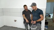 Thomas Wittenberg und Mike Schopp mit Fugenmasse f&uuml;r die Bodenfliesen.